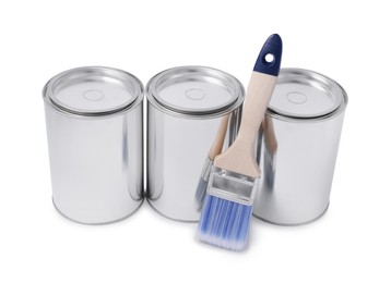 Cans of paints and brush on white background