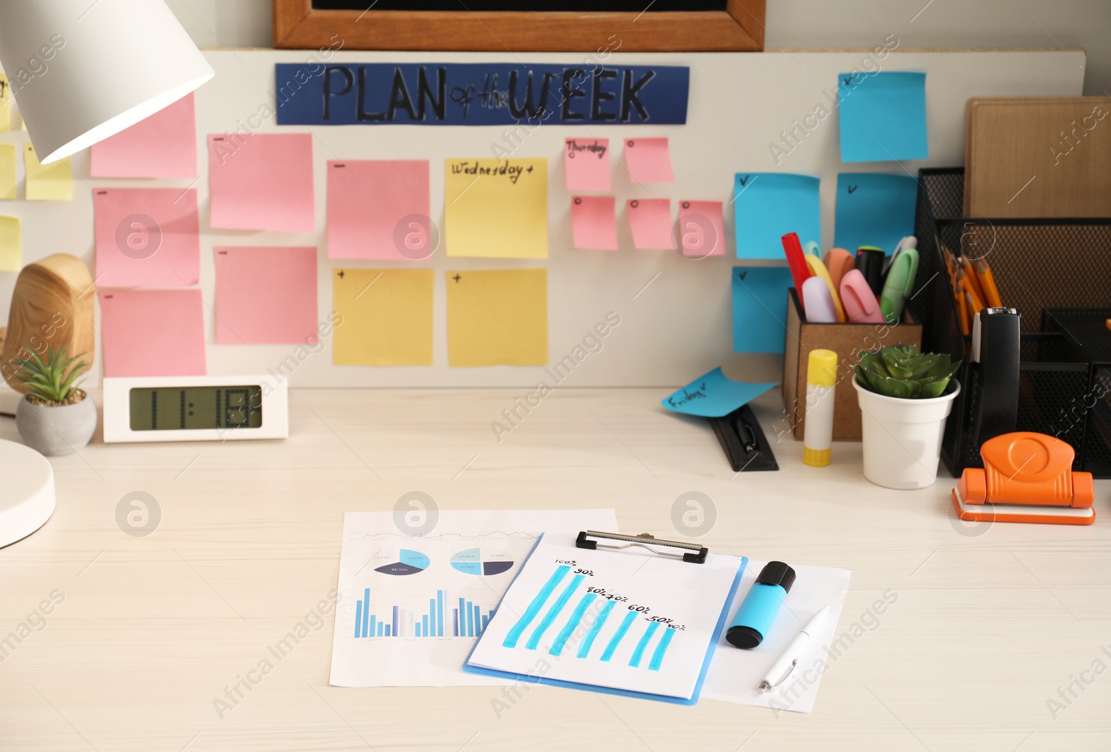 Photo of Business process planning and optimization. Workplace with lamp, colorful paper notes and other stationery on white wooden table