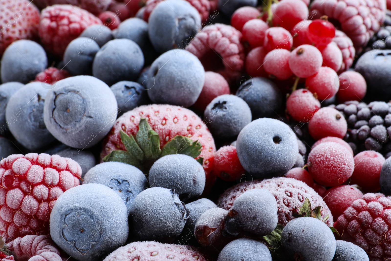 Photo of Mix of different frozen tasty berries as background, closeup