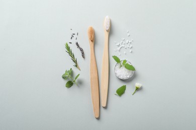 Flat lay composition with toothbrushes and herbs on white background