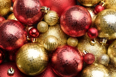 Beautiful shiny golden and red Christmas balls as background, top view