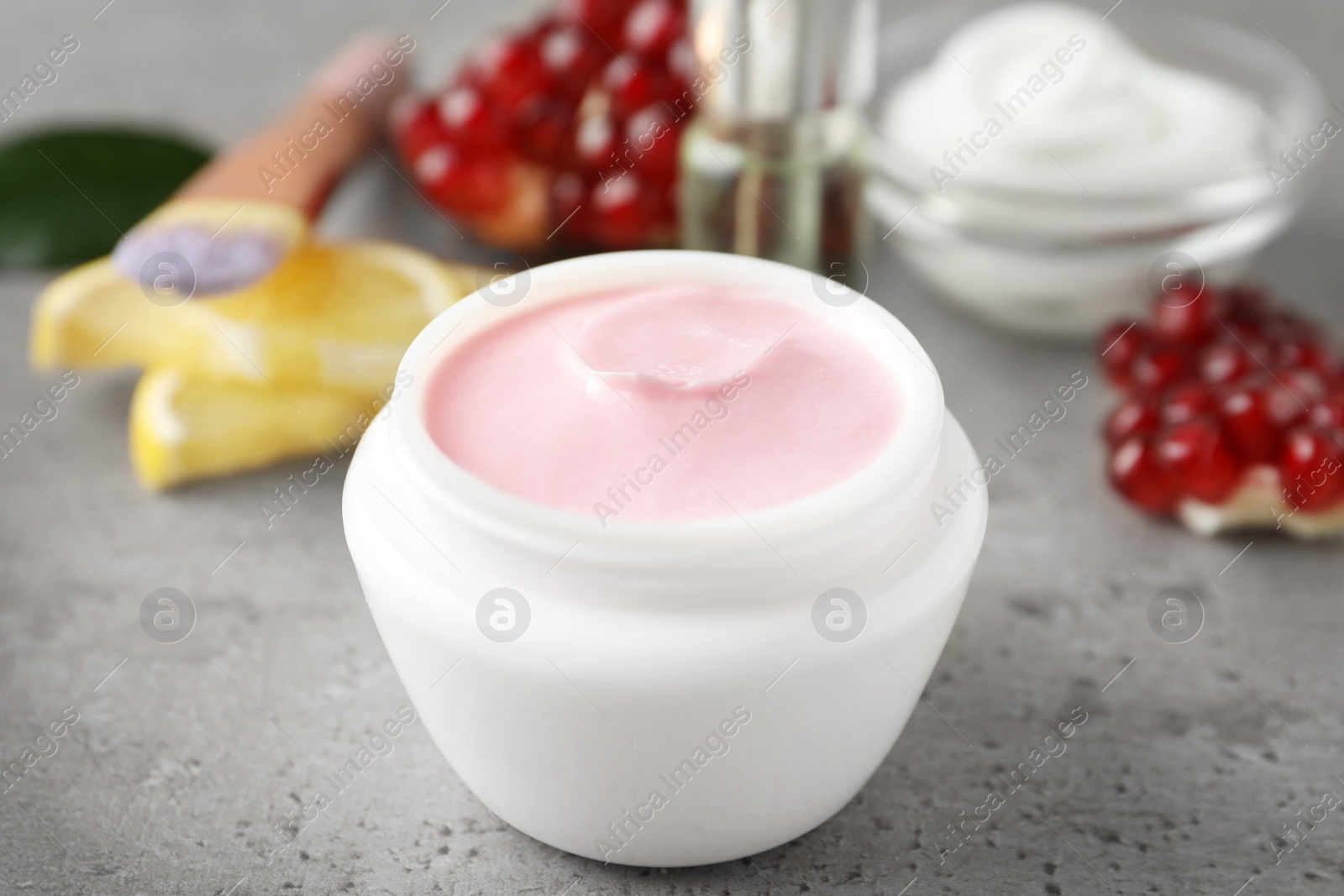 Photo of Natural pomegranate facial mask on light grey table, closeup