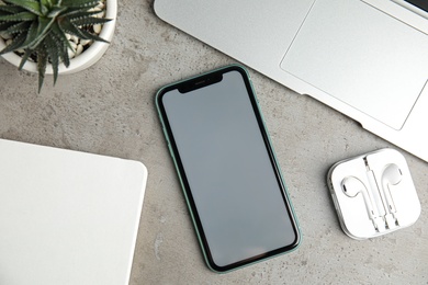MYKOLAIV, UKRAINE - JULY 9, 2020: Iphone 11 and AirPods on light grey table, flat lay. Mockup for design