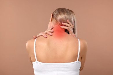 Woman suffering from neck pain on dark beige background, back view
