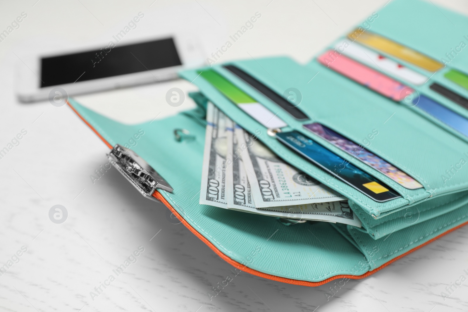 Photo of Stylish wallet with cash and credit cards on light background, closeup