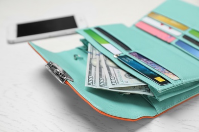 Photo of Stylish wallet with cash and credit cards on light background, closeup