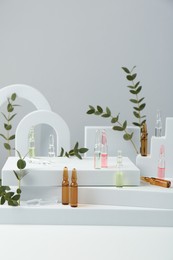 Stylish presentation of different skincare ampoules on white background