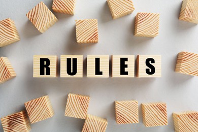 Word Rules made of wooden cubes with letters on white background, flat lay