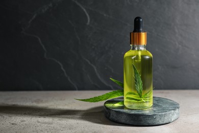 Photo of Hemp essential oil serum and leaf on light table. Space for text