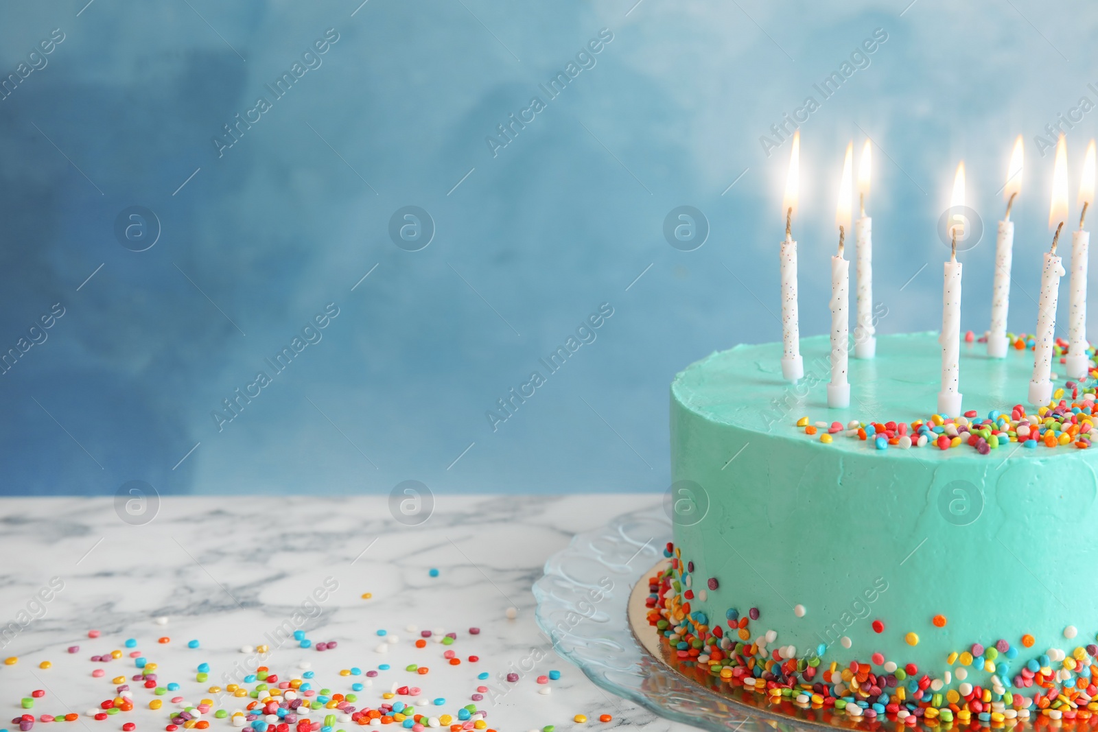 Photo of Fresh delicious birthday cake with candles on table against color background. Space for text