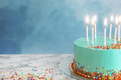 Fresh delicious birthday cake with candles on table against color background. Space for text