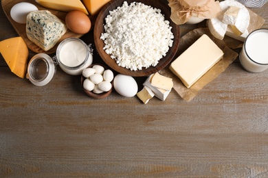 Photo of Different dairy products on wooden table, flat lay. Space for text