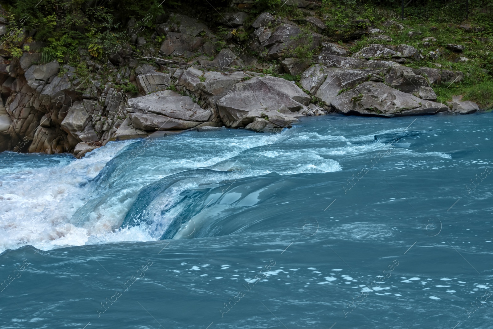 Photo of Mountain river flowing along rocky banks in wilderness