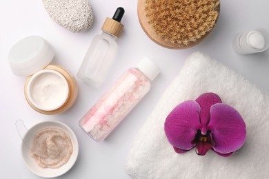 Flat lay composition with different spa products and beautiful flower on white table