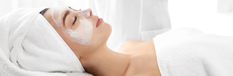 Image of Pretty woman with mask on her face in spa salon. Banner design