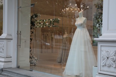 Photo of Showcase with beautiful wedding dress on mannequin