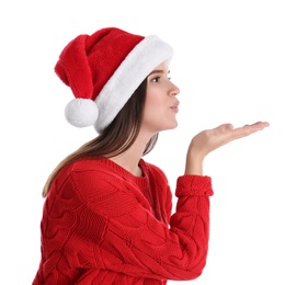 Photo of Pretty woman in Santa hat and red sweater blowing kiss on white background