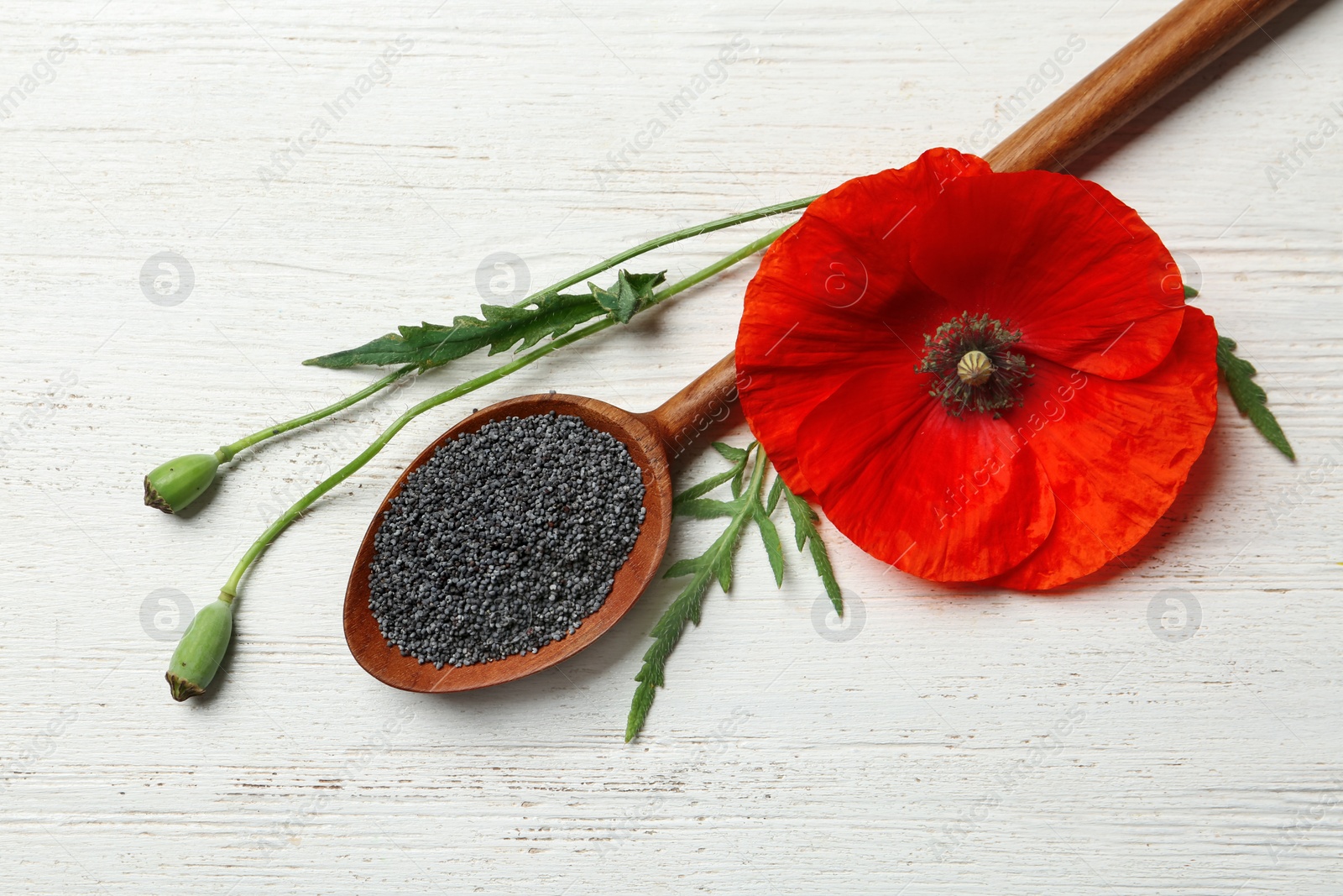 Photo of Flat lay composition with poppy seeds and flower on wooden table