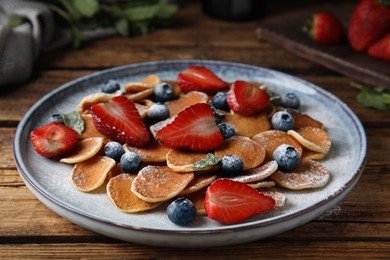 Photo of Cereal pancakes with berries on wooden table