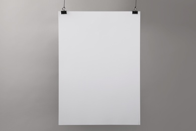 White blank poster hanging near grey wall