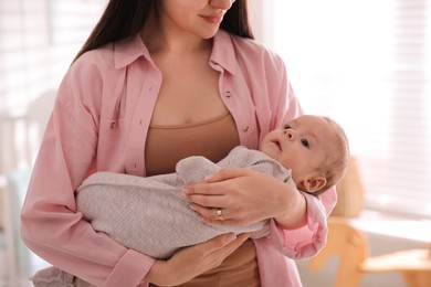 Young woman with her cute baby indoors, closeup