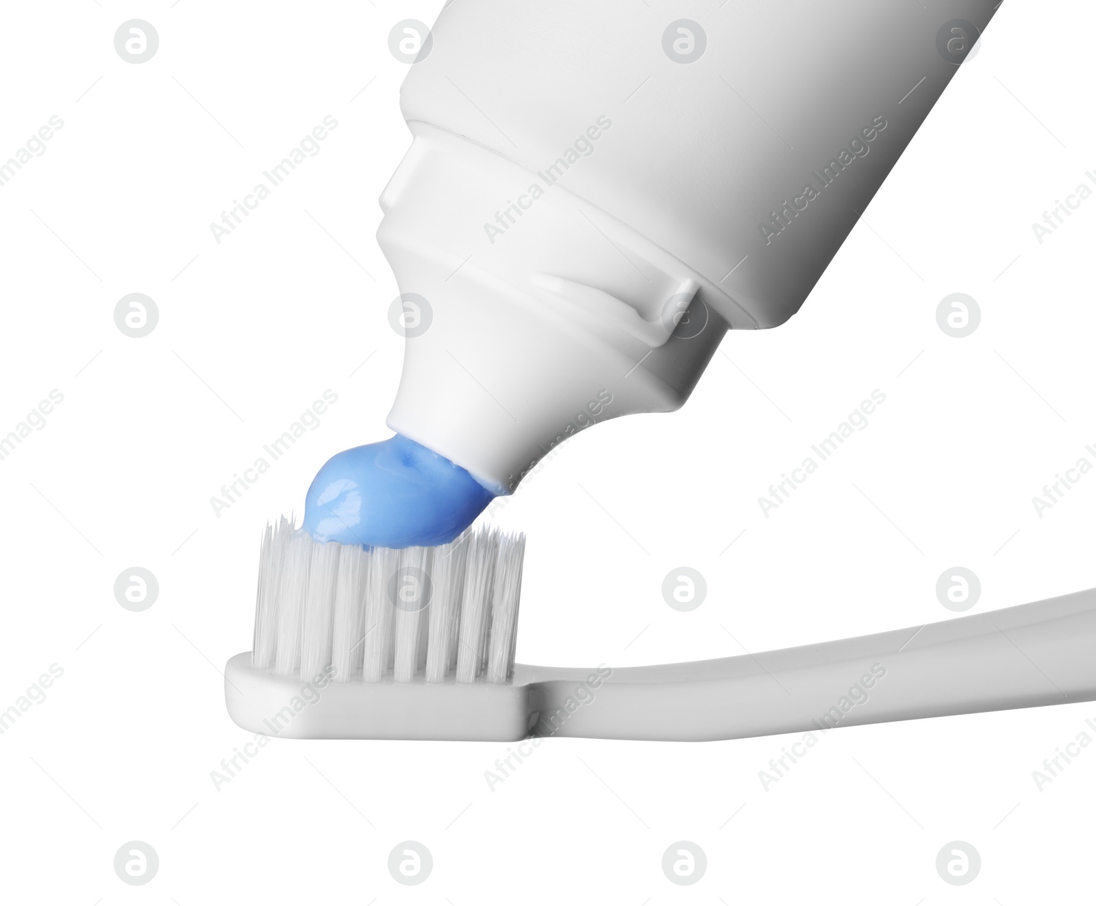 Photo of Applying paste on toothbrush against white background, closeup