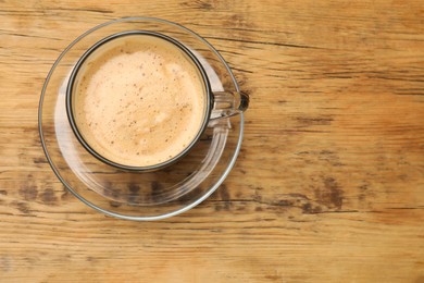 Photo of Cup of aromatic coffee on wooden table, top view. Space for text