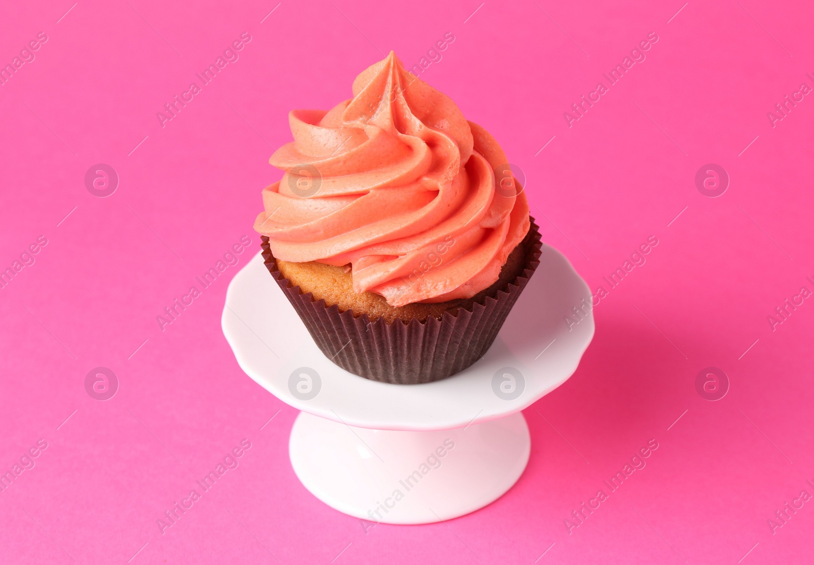 Photo of Delicious cupcake with bright cream on pink background