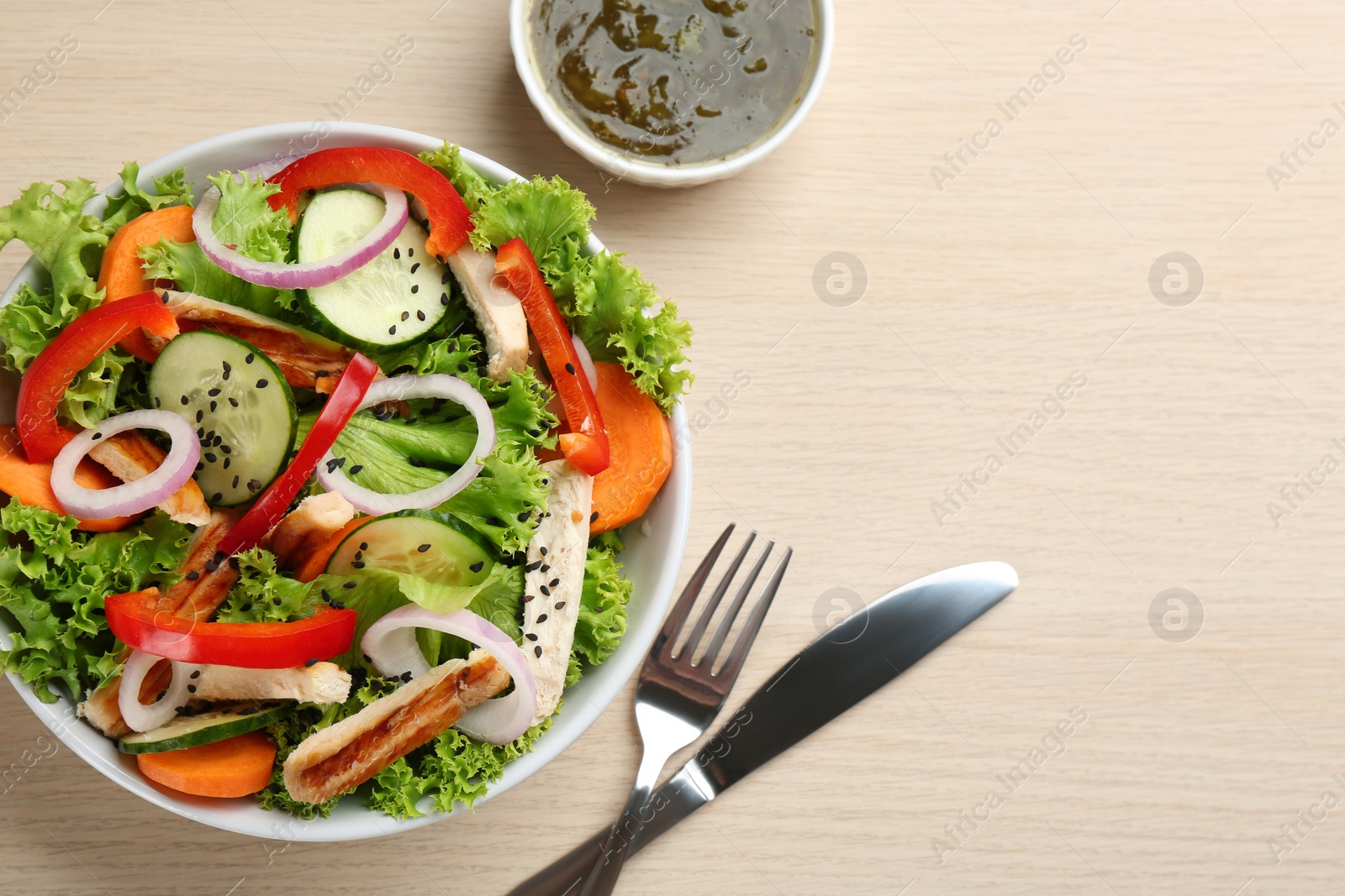 Photo of Delicious fresh chicken salad served on wooden table, flat lay. Space for text