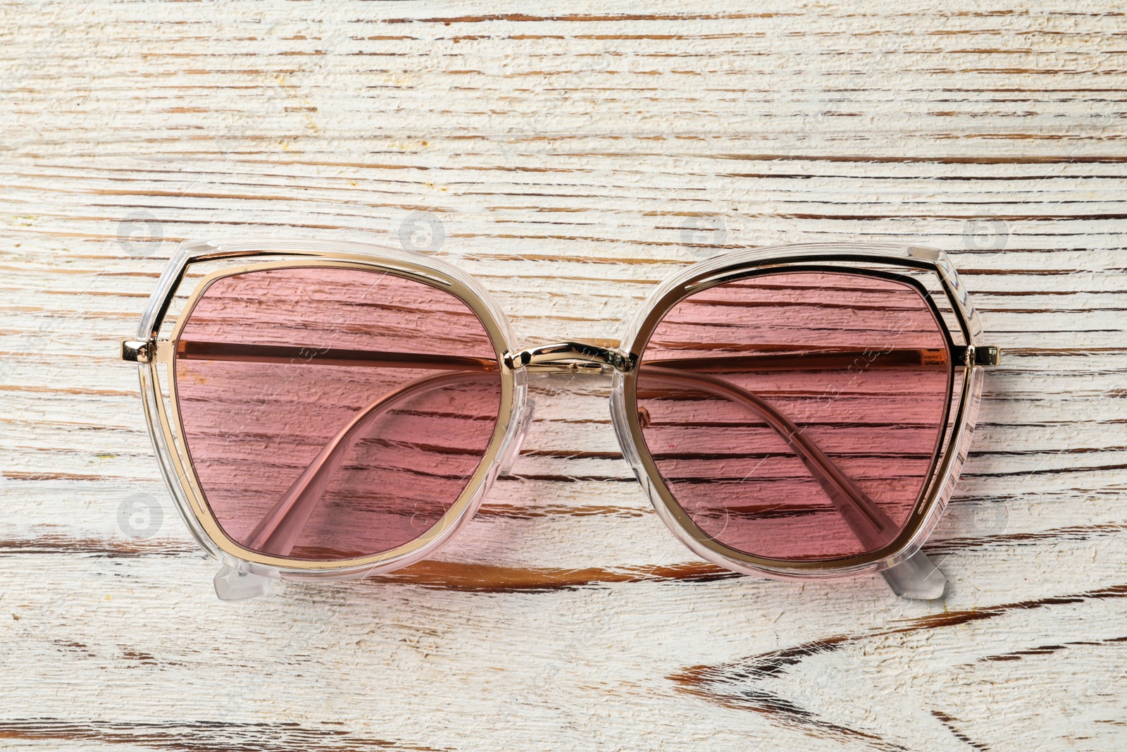 Photo of New stylish sunglasses on white wooden table, top view