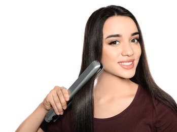 Happy woman using hair iron on white background