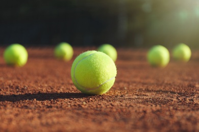 Photo of Bright yellow tennis ball on clay court
