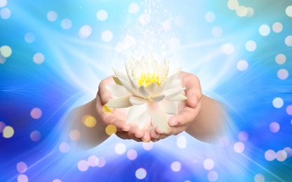 Woman holding beautiful lotus flower on bright background, closeup