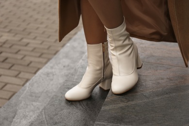 Woman wearing stylish leather shoes on stairs outdoors, closeup