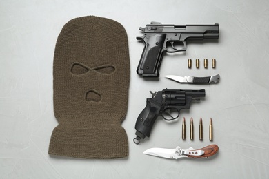 Photo of Flat lay composition with balaclava and weapons on white table