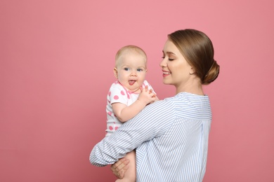 Portrait of happy mother with her baby on color background