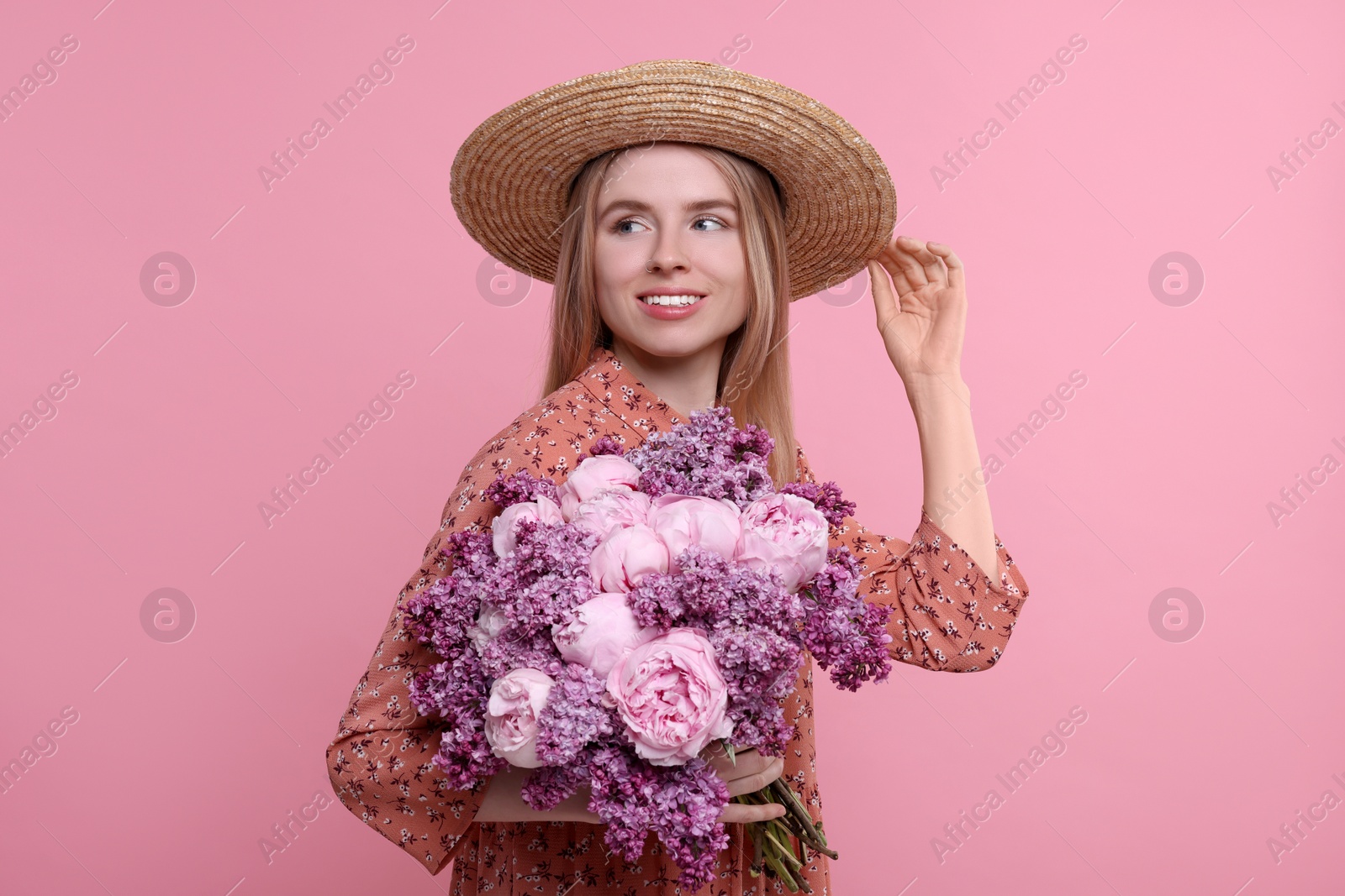 Photo of Beautiful woman with bouquet of spring flowers on pink background