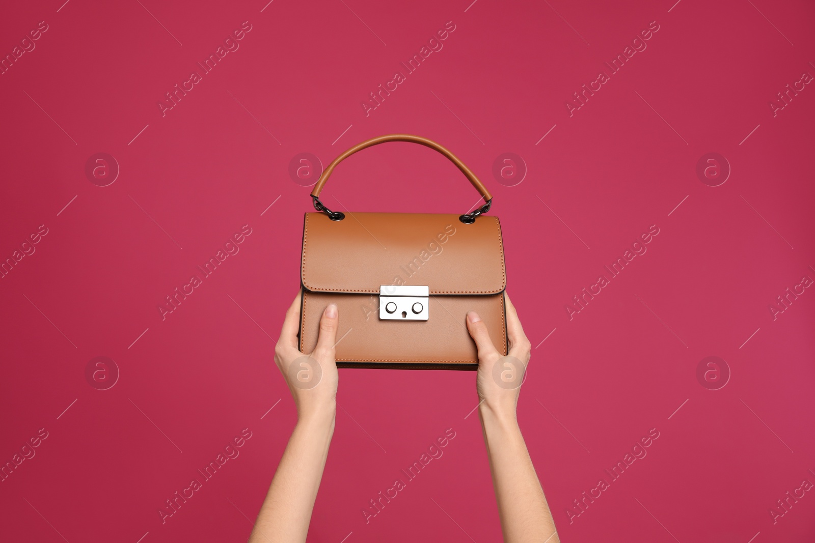 Photo of Woman holding stylish handbag on pink background, closeup