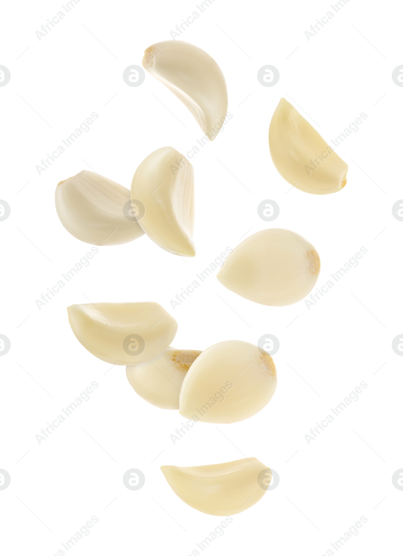 Image of Fresh garlic cloves falling on white background