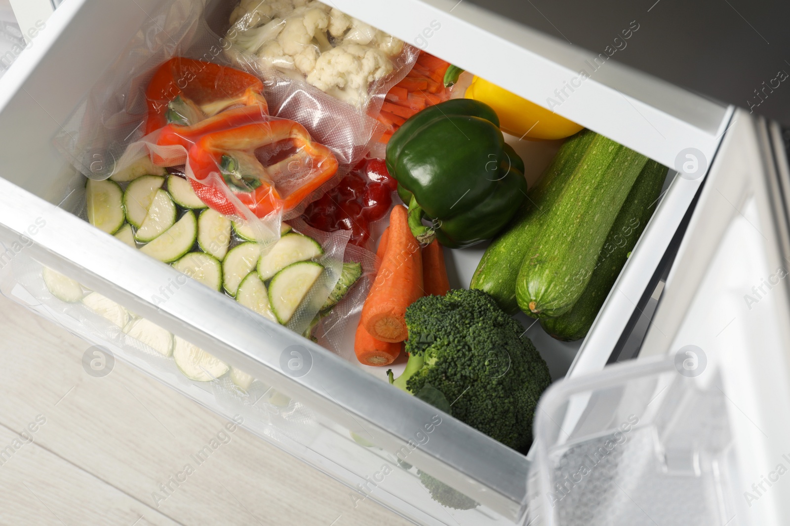 Photo of Vacuum bags with different products in fridge, above view. Food storage