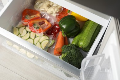 Vacuum bags with different products in fridge, above view. Food storage