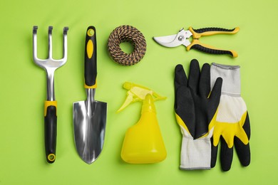 Photo of Flat lay composition with gardening tools on green background