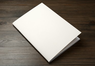 Blank paper brochure on wooden table. Mockup for design