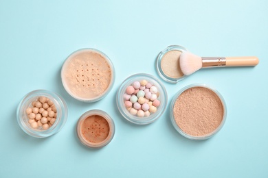 Photo of Flat lay composition with various makeup face powders on color background