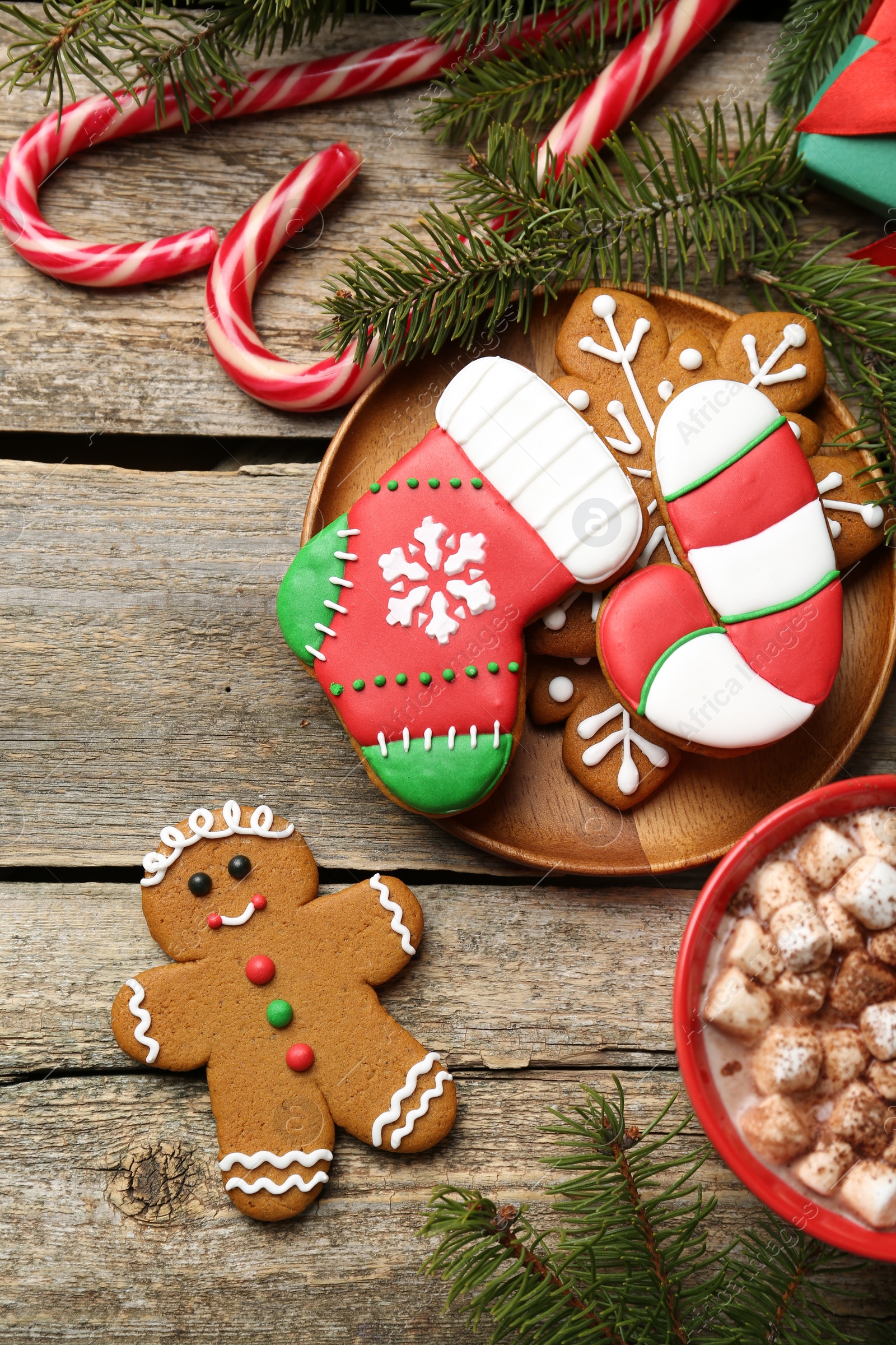 Photo of Different tasty Christmas cookies, decor and cocoa with marshmallows on wooden table, flat lay