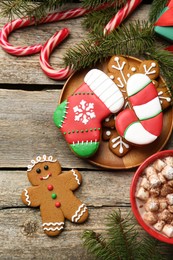 Different tasty Christmas cookies, decor and cocoa with marshmallows on wooden table, flat lay