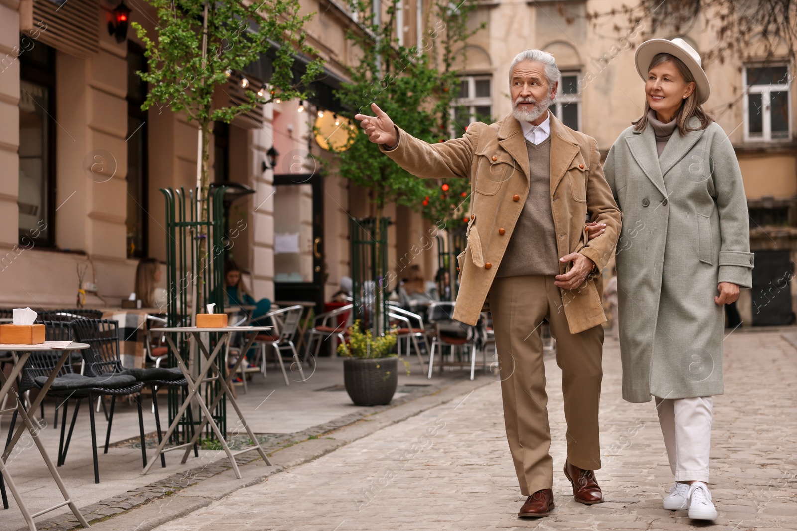 Photo of Portrait of affectionate senior couple walking outdoors, space for text