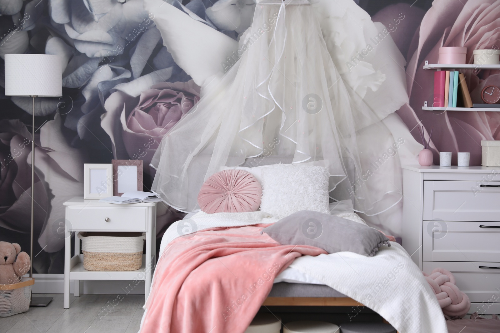 Photo of Teenage girl's room interior with comfortable bed and floral wallpaper. Idea for stylish design