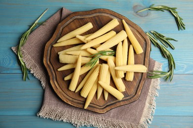 Photo of Fresh baby corn cobs on blue wooden table, flat lay