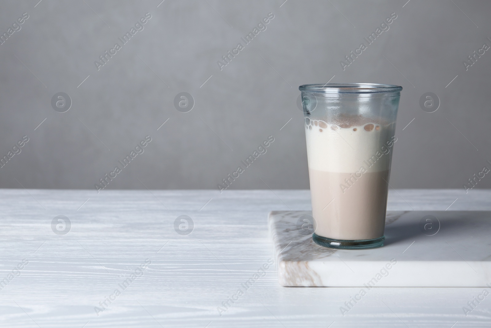 Photo of Glass with protein shake on table. Space for text